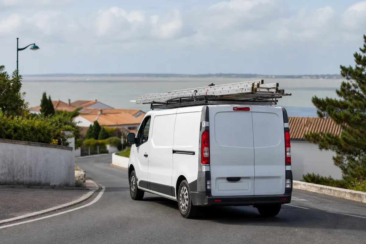 Fourgon d’artisan couvreur avec échelle sur une route côtière de Charente-Maritime